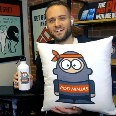 Joe Robert of POD Ninjas, holding a POD Ninjas cushion.